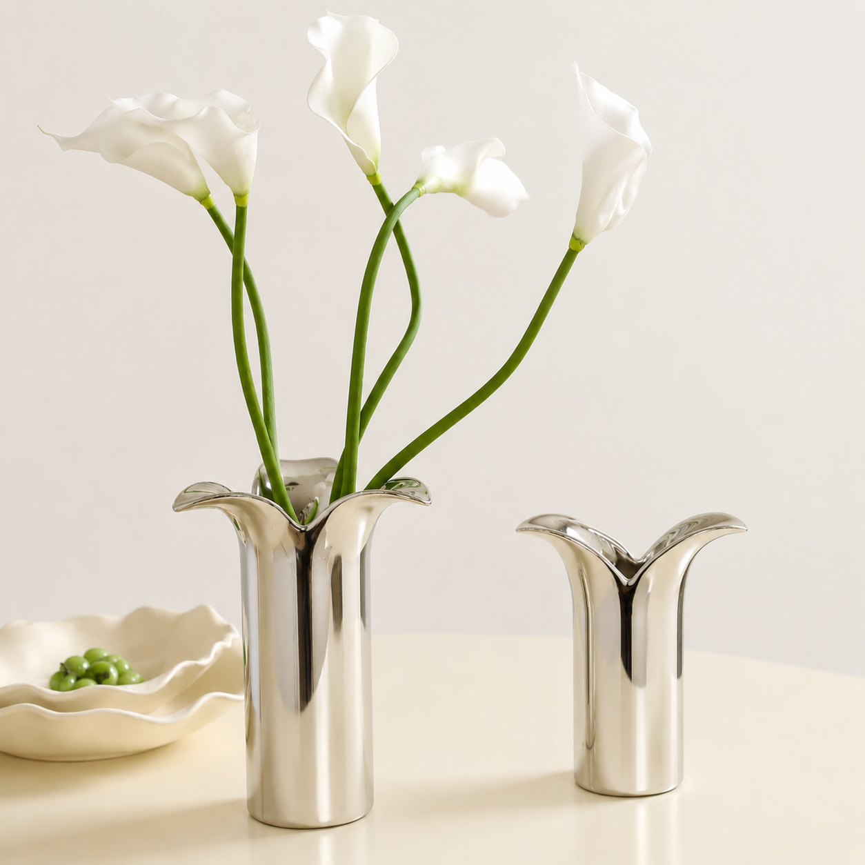 Дизайнерски керамични вази Magnolia Silver и Magnolia Petite с бели кали в светъл минималистичен интериор.